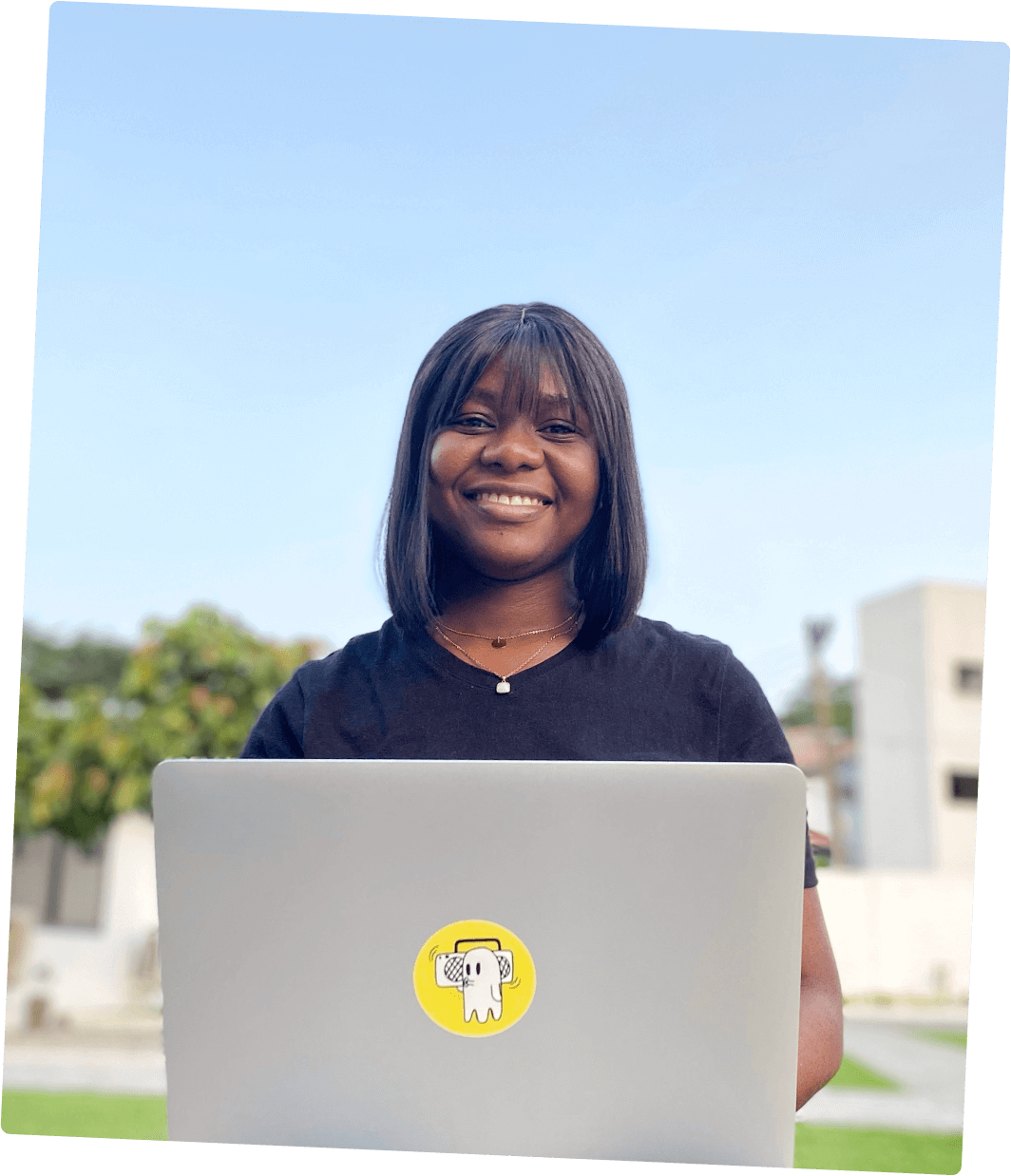Stella Inabo facing the camera smiling with a laptop